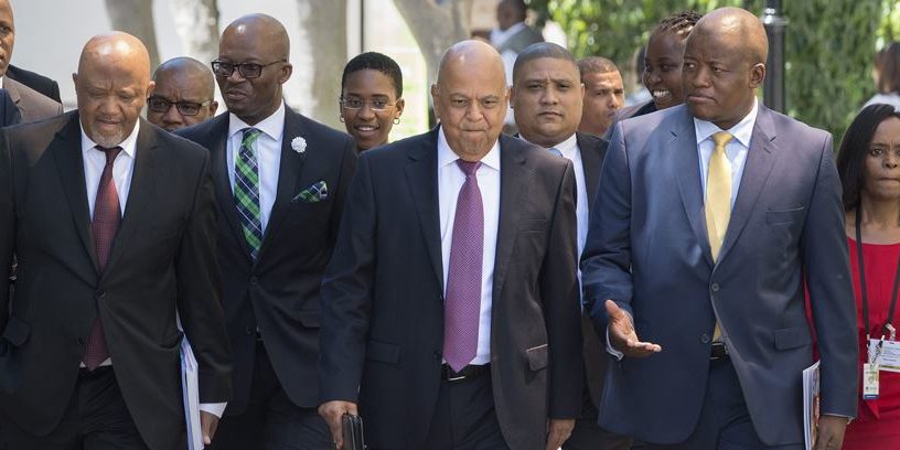 Pravin Gordhan walks with members of the Finance Ministry